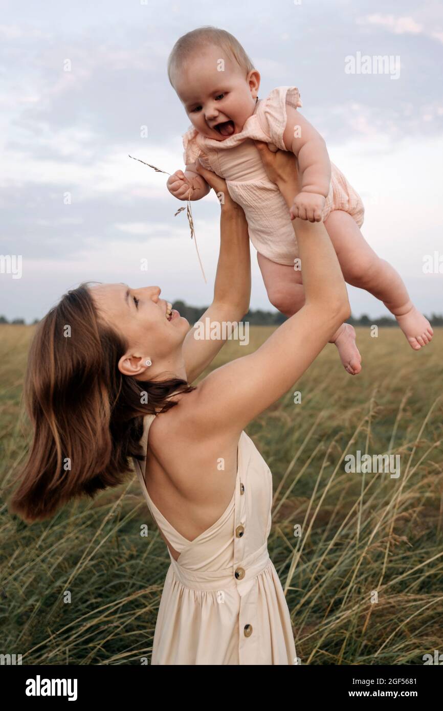 Ragazza allegra che gioca con la bambina in campo Foto Stock