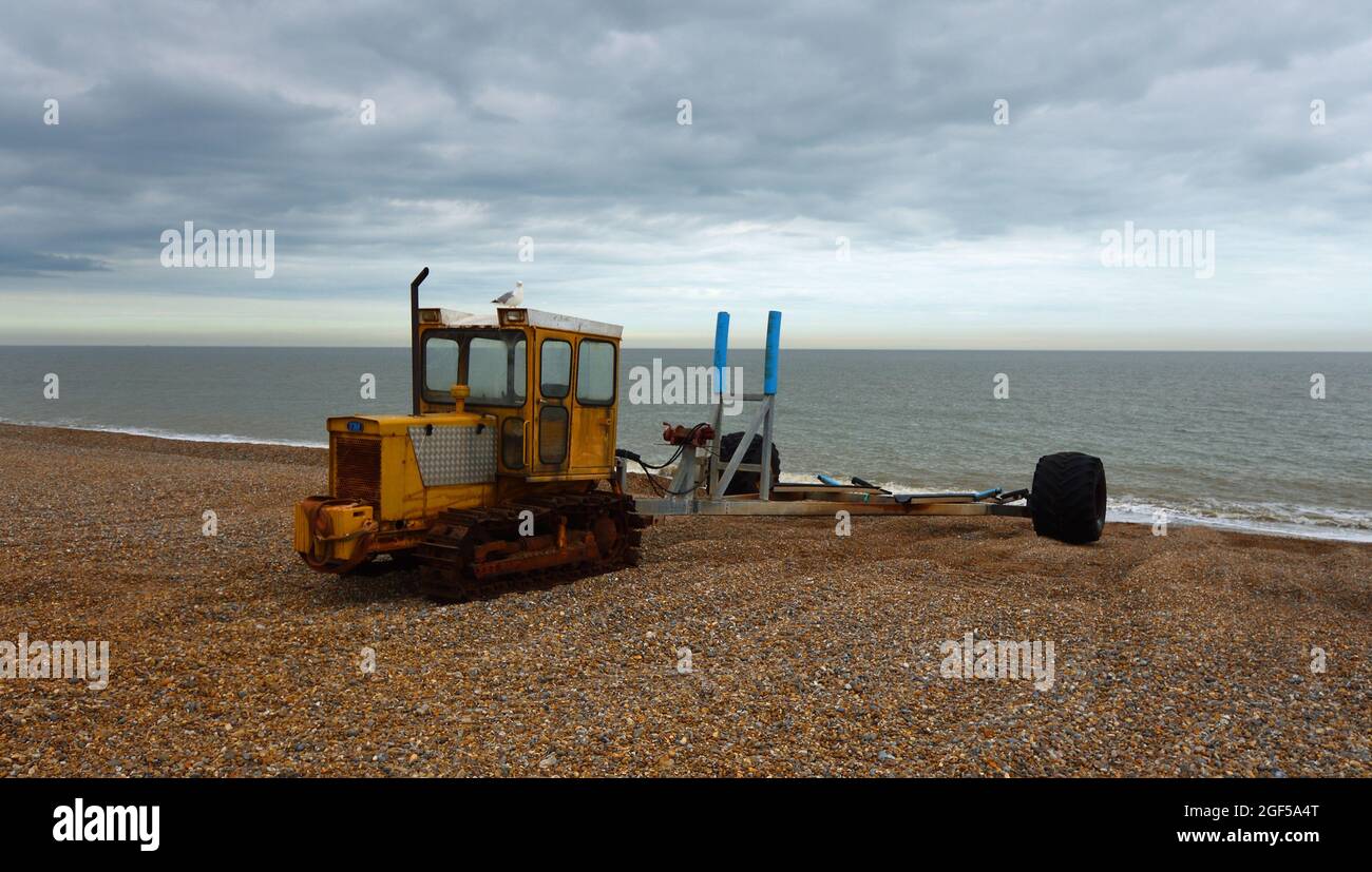 La Caterpillar Tractor sulla spiaggia di Aldeburgh utilizzato per il traino di barche da pesca in e fuori del mare Foto Stock