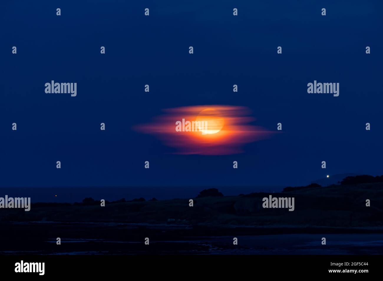 Dunbar, East Lothian, Scozia, Regno Unito, 23 agosto 2021. UK Meteo: Moonrise. Una vista della luna piena di agosto conosciuta come la luna sturgeon nel cielo notturno Foto Stock