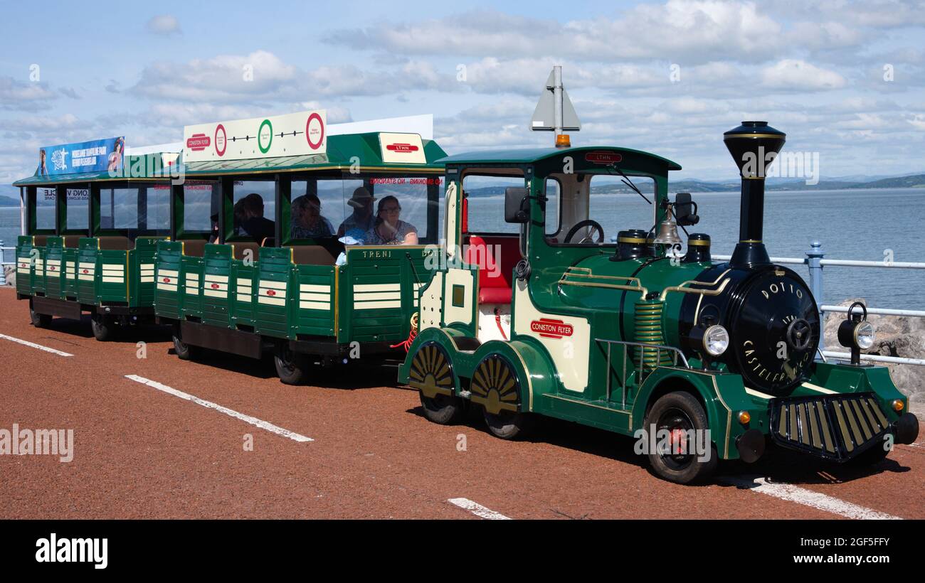 Una corsa in trenino per prendere i passeggeri per un giro lungo la passeggiata alla località balneare di Morecambe, Lancashire, Inghilterra, Regno Unito. Foto Stock