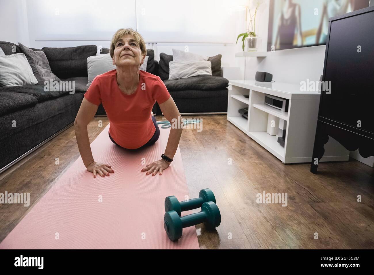 Senior woman doing online yoga sport workout class a casa - sano e benessere concetto di stile di vita anziani - Focus on face Foto Stock