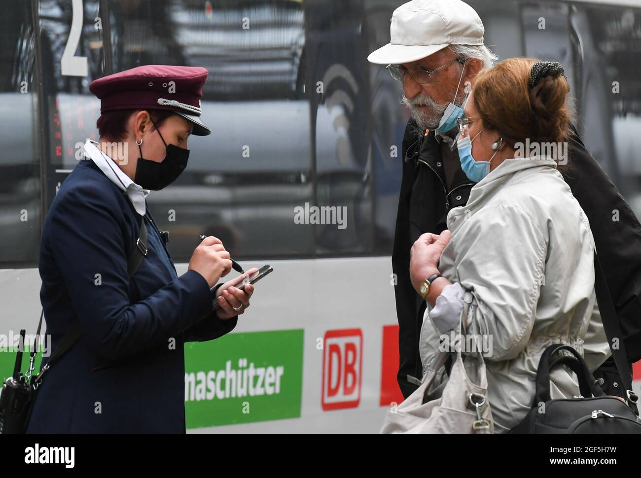Francoforte, Germania. 23 Agosto 2021. Un membro del personale della Deutsche Bahn (DB) (L) parla con i passeggeri durante uno sciopero dei macchinisti alla stazione centrale di Francoforte, in Germania, il 23 agosto 2021. Lo sciopero è stato causato da un fallimento dei negoziati tariffari tra la German Train Drivers' Union (GDL) e l'operatore ferroviario statale Deutsche Bahn (DB). Credit: LU Yang/Xinhua/Alamy Live News Foto Stock