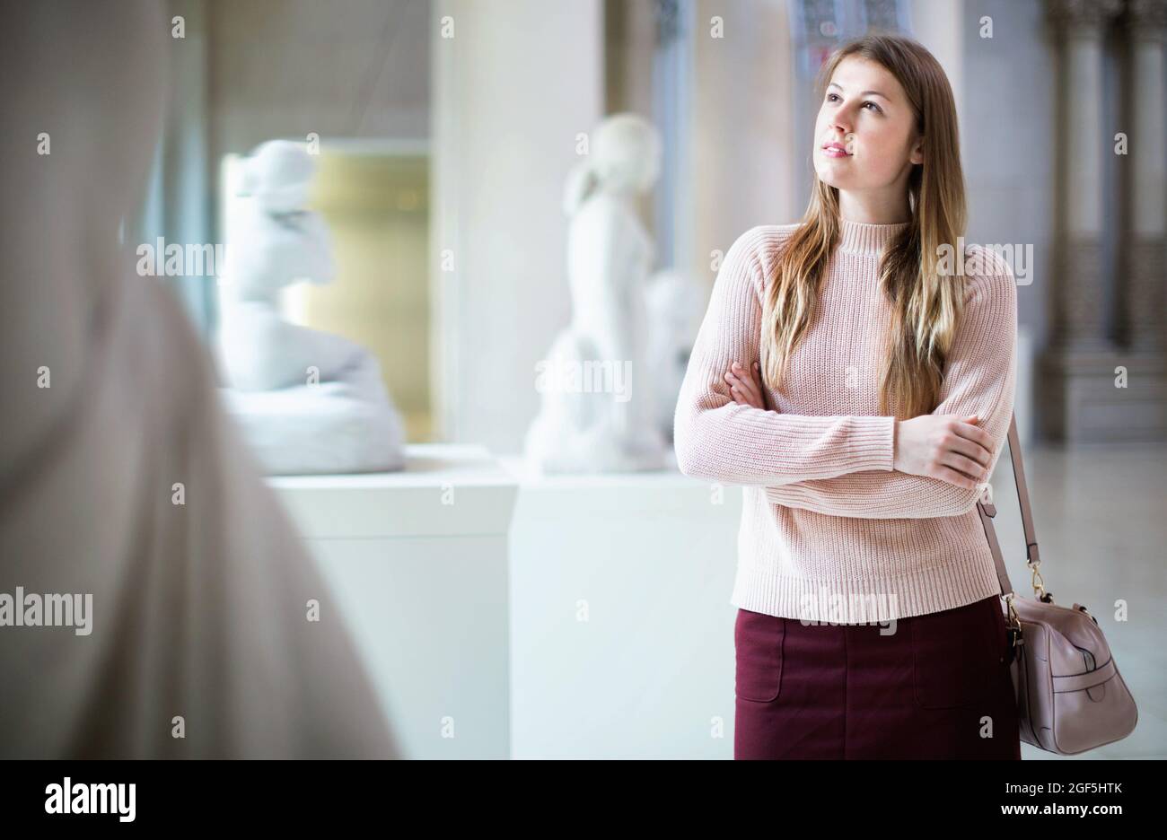 Ritratto di giovane donna in piedi vicino esposizione nel museo d'arte Foto Stock