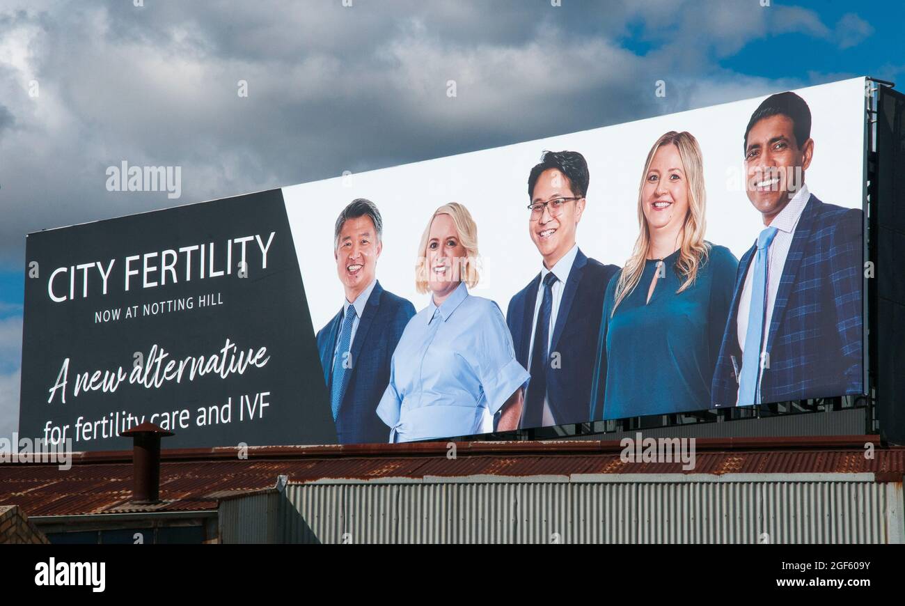 Billboard pubblicizza una clinica IVF (in vitro Fertilization) nella periferia di Melbourne, Australia. I ritratti del personale evidenziano la diversità etnica Foto Stock