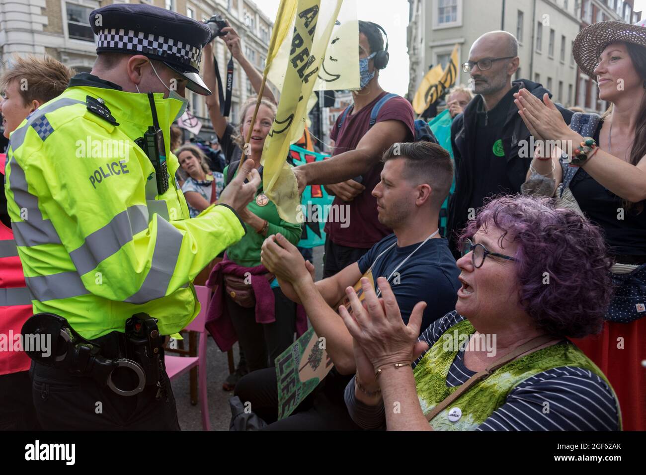 Londra, Regno Unito. 23 Agosto 2021. Gli ufficiali di polizia parlano ai manifestanti per strada durante la manifestazione.la ribellione dell'estinzione UK ha lanciato una protesta a Covent Garden a Londra per sensibilizzare il pubblico sulle questioni legate al cambiamento climatico, esortando il governo ad agire. I manifestanti sono stati visti scontrarsi con i membri della forza di polizia DEL MET ( Metropolitan ) in tutto il tempo. Alcuni manifestanti si sono bloccati sotto furgoni e si sono rifiutati di lasciare lo spazio. (Foto di Belinda Jiao/SOPA Images/Sipa USA) Credit: Sipa USA/Alamy Live News Foto Stock