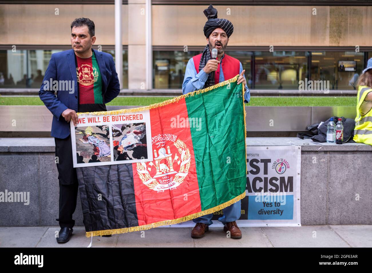 Londra, Regno Unito. 23 Agosto 2021. I manifestanti detengono una bandiera afghana durante la manifestazione. In seguito alla recente presa della capitale afghana Kabul da parte dei talebani, la diaspora afghana a Londra si è riunita al di fuori dell'ufficio nazionale per esprimere solidarietà a quella afghana. Chiedevano un'azione urgente da parte del governo di Boris Johnson per proteggere i familiari le cui vite sono minacciate, in particolare mettendo in luce i diritti delle donne e dei bambini. Credit: SOPA Images Limited/Alamy Live News Foto Stock