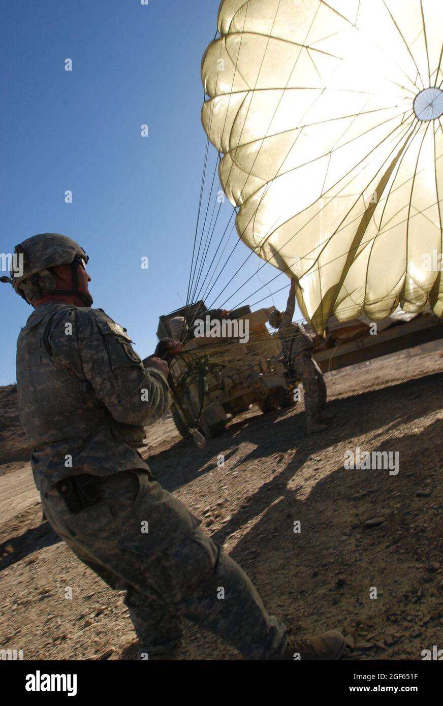 Esercito Sgt. Mike Fogleman, un capo squadra mortaio della sede centrale e della sede centrale della Società, 1° Battaglione (Airborne) 503° Fanteria, 173° Brigata Airborne, lotta per impedire a un paracadute di soffiare via dopo essere stato staccato dalle forniture che ha portato a terra nella provincia di Paktika, Afghanistan, 9 novembre. Fogleman è di Locust Grove, OK. Foto Stock