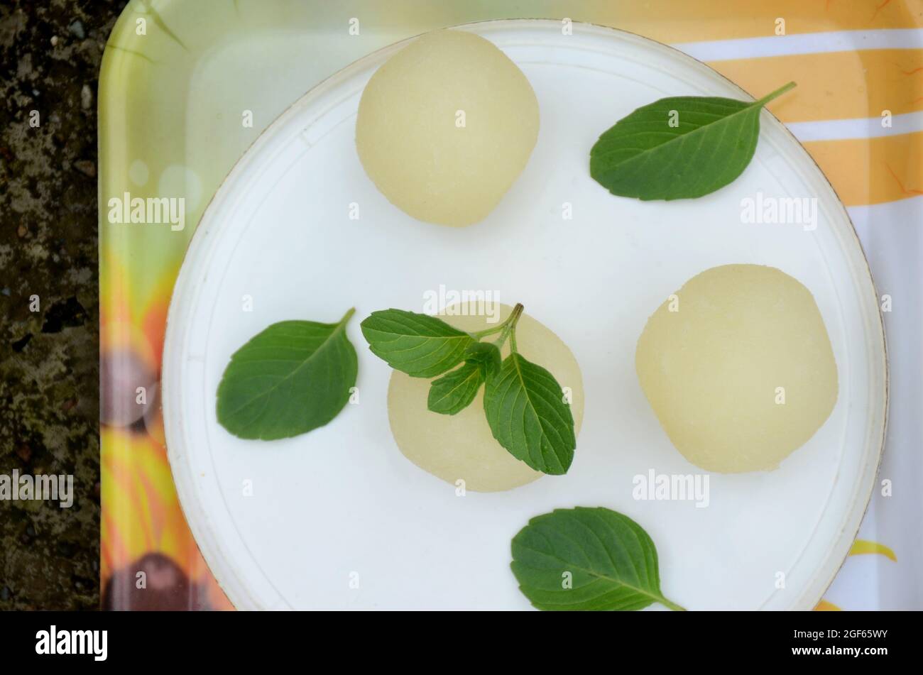 primo piano il mazzo di sciroppo riempito palla dolce con menta verde su fuori fuoco bianco giallo sfondo. Foto Stock