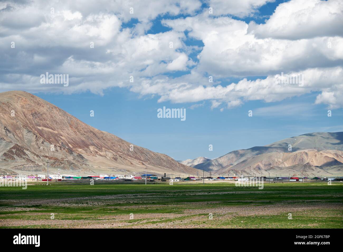 Tsagaannuur mongolo insediamento vicino montagne sotto cielo blu e nuvole Foto Stock