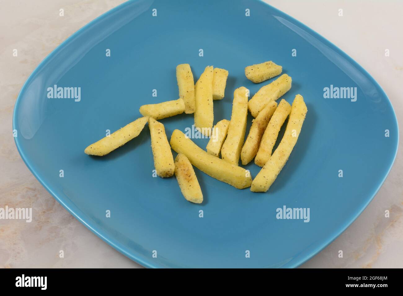 Patatine fritte al tartufo nero su piatto blu snack al tavolo Foto Stock