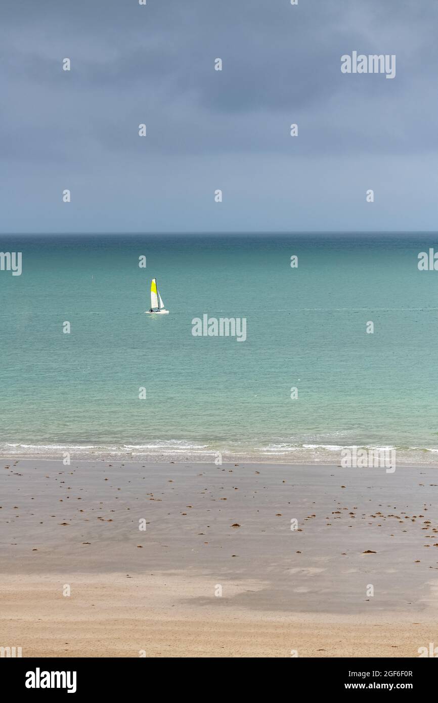 Bella spiaggia a Agon-Coutainville in Normandia, con una barca a vela sul mare Foto Stock