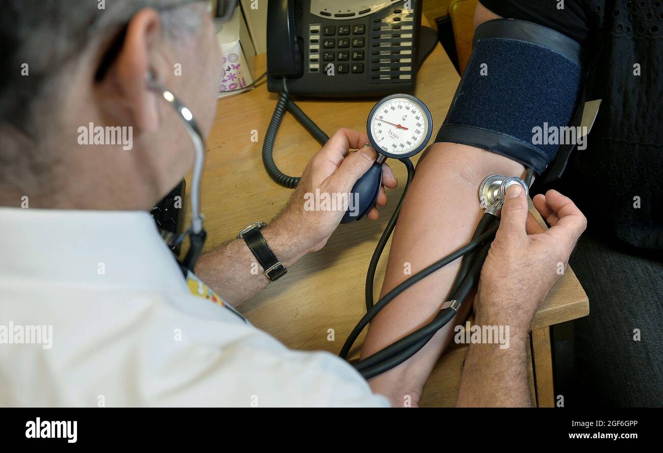 Foto del fascicolo del 10/09/14 di un GP che controlla la pressione sanguigna di un paziente. Quasi la metà della gente ritiene che il miglioramento superiore all'ambulatorio dei loro medici locali sarebbe più GPS, un sondaggio ha suggerito. Data di emissione: Martedì 24 agosto 2021. Foto Stock