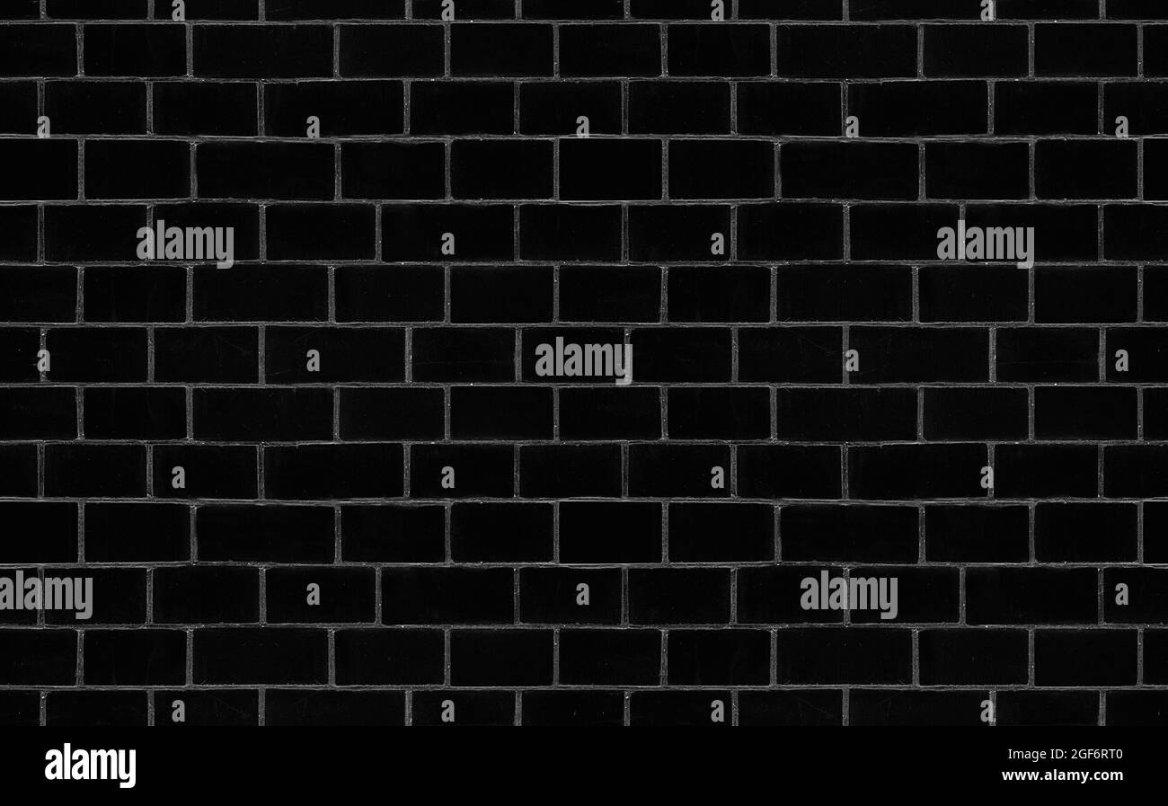 Motivo vintage rustico senza cuciture con parete in mattoni neri senza cuciture sfondo nero. Vecchio muro di cemento texture sfondo. Foto Stock