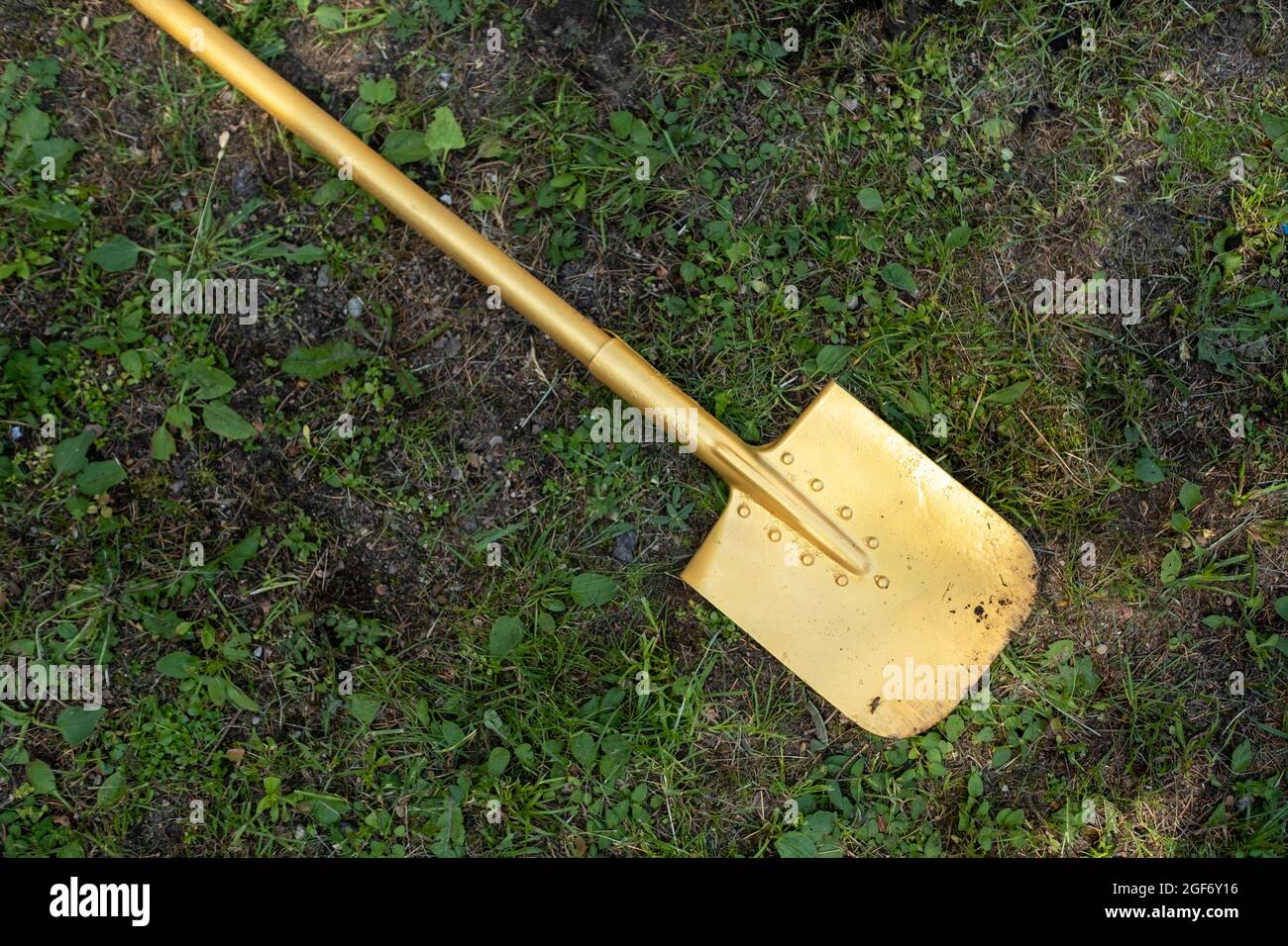 Una pala d'oro si trova sulla cerimonia di apertura dell'erba Foto Stock