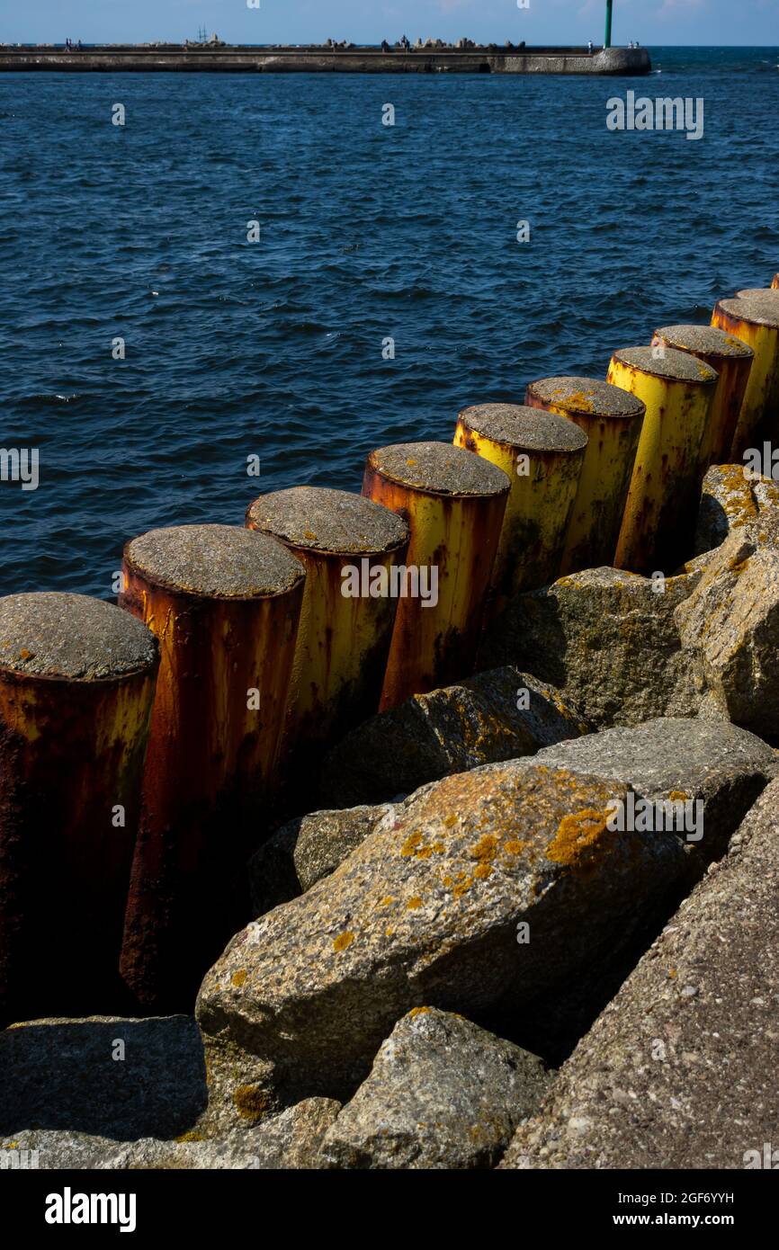 Pali di acciaio che proteggono la banchina del porto. Foto scattata in buone condizioni di illuminazione in una giornata di sole Foto Stock