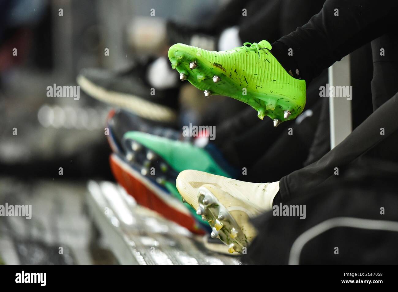Scarpe da calcio professionali con borchie di giocatori seduti in panchina Foto Stock