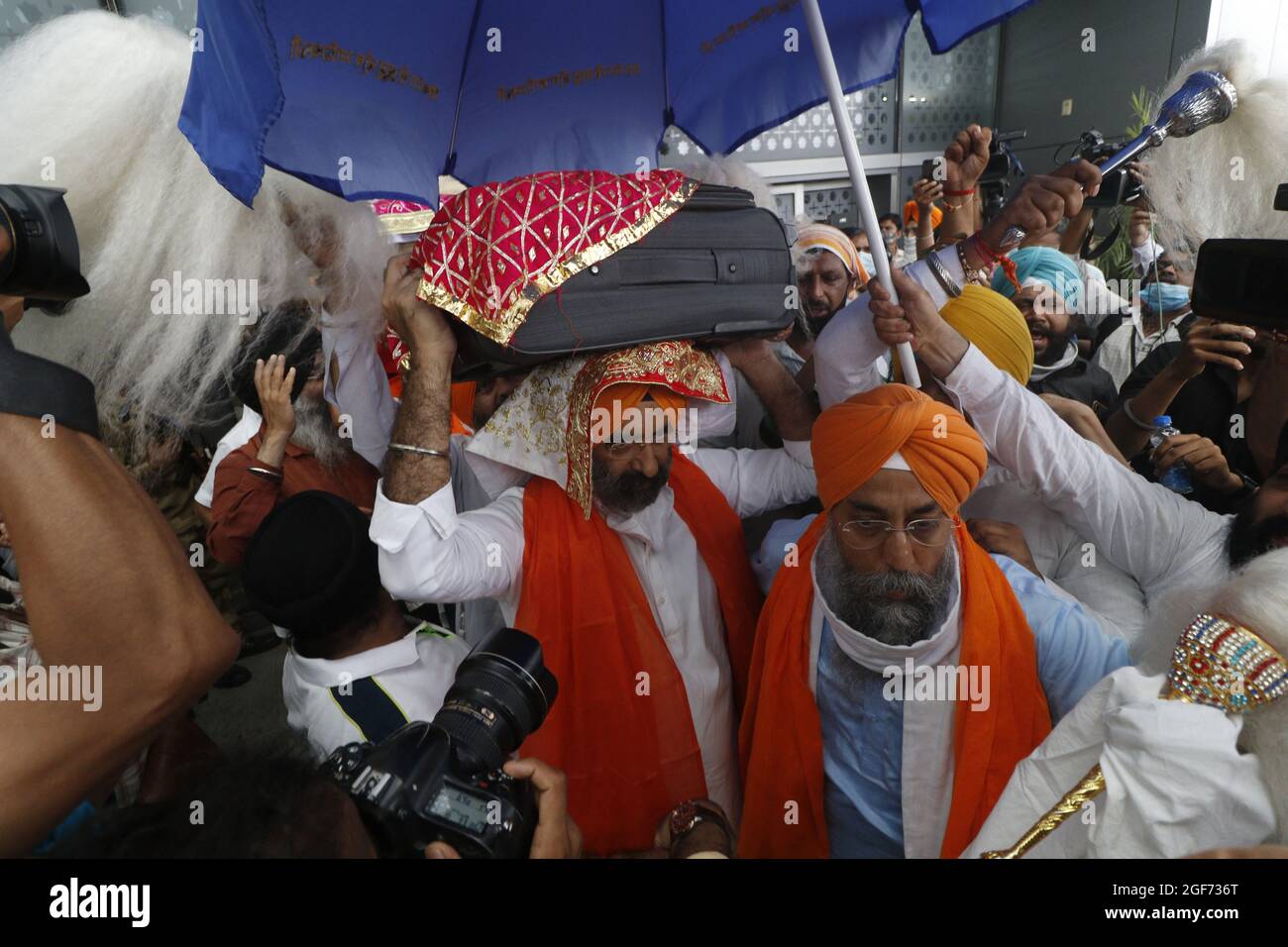 I membri del riligione Sikh trasportano 3 Saroops di Sri Guru Granth Sahib, la sacra Scrittura al T3, aeroporto IGI a Nuova Delhi, India il 24 agosto 2021. Photo by Anshuman Akash/ABACAPRESS.COM Credit: Abaca Press/Alamy Live News Foto Stock