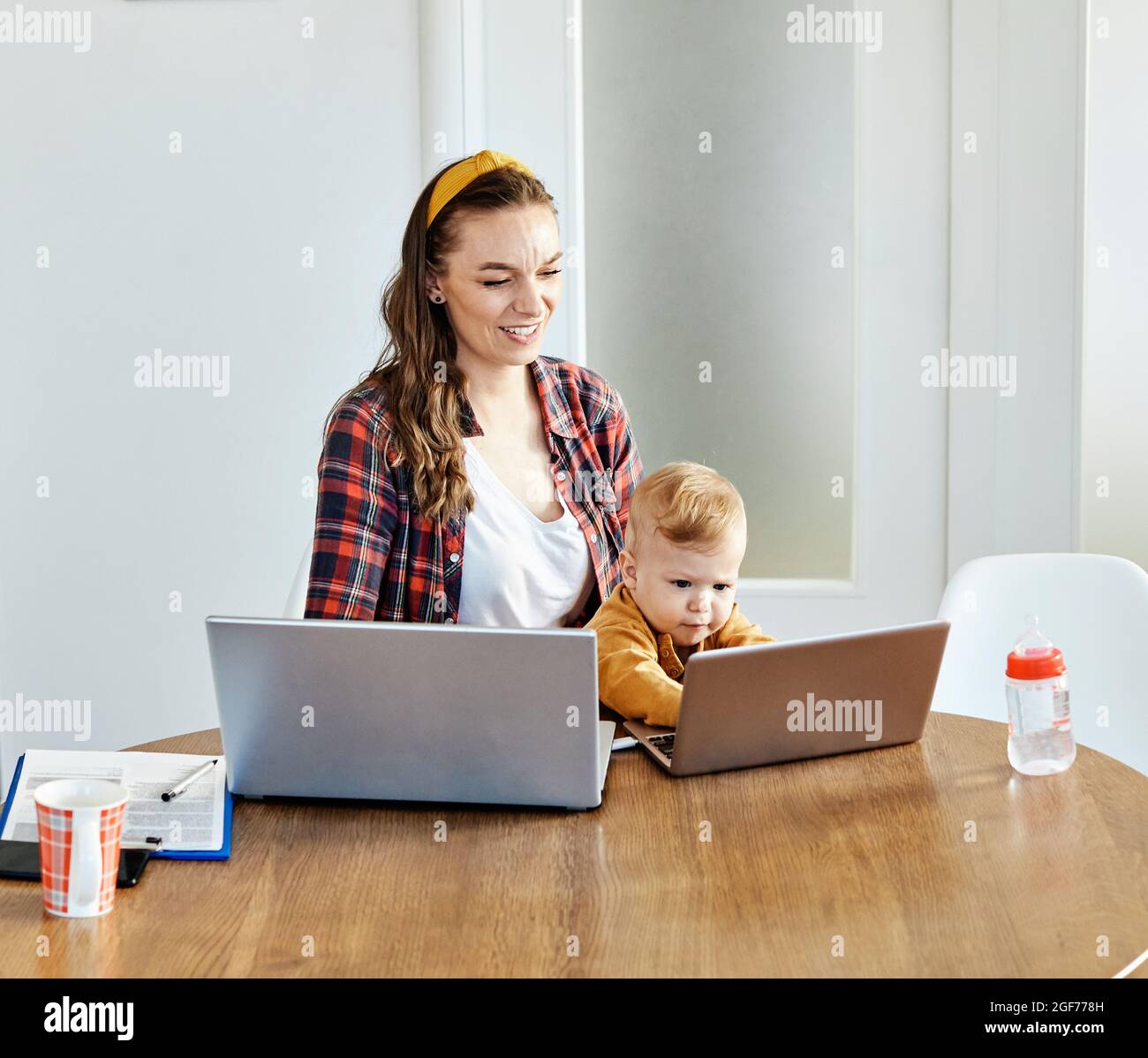 madre bambino laptop computer bambino donna lavoro famiglia madre madre madre mamma Foto Stock