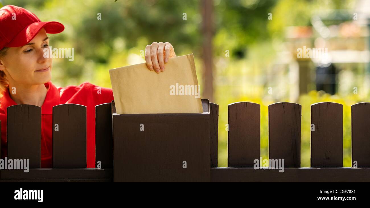 supporto di posta inserimento della lettera nella mailbox sopra la fence. spazio di copia banner Foto Stock