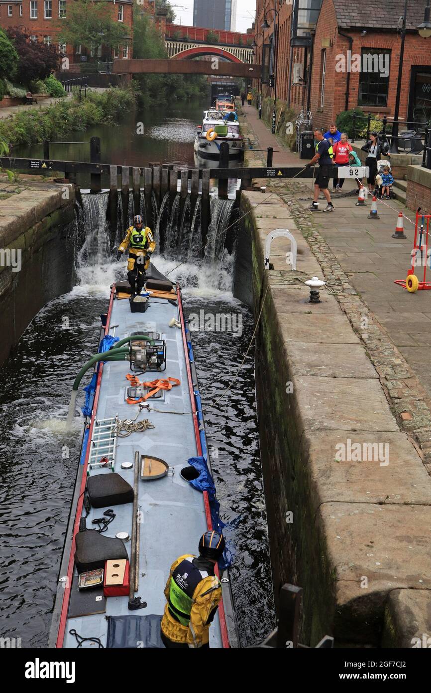 L'acqua viene pompata da una barca del canale affondata nel blocco 92 del canale Rochdale quando inizia a galleggiarla nuovamente. Questa è l'immagine 4 dell'operazione di salvataggio Foto Stock