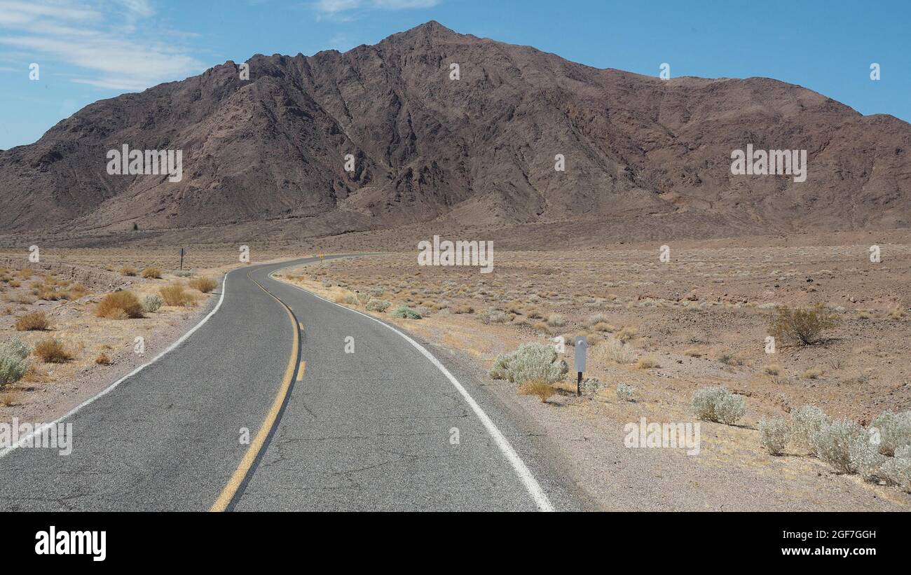 Lonely lungo la strada attraverso il paesaggio del deserto, Highway 190, il Parco Nazionale della Valle della Morte, CALIFORNIA, STATI UNITI D'AMERICA Foto Stock