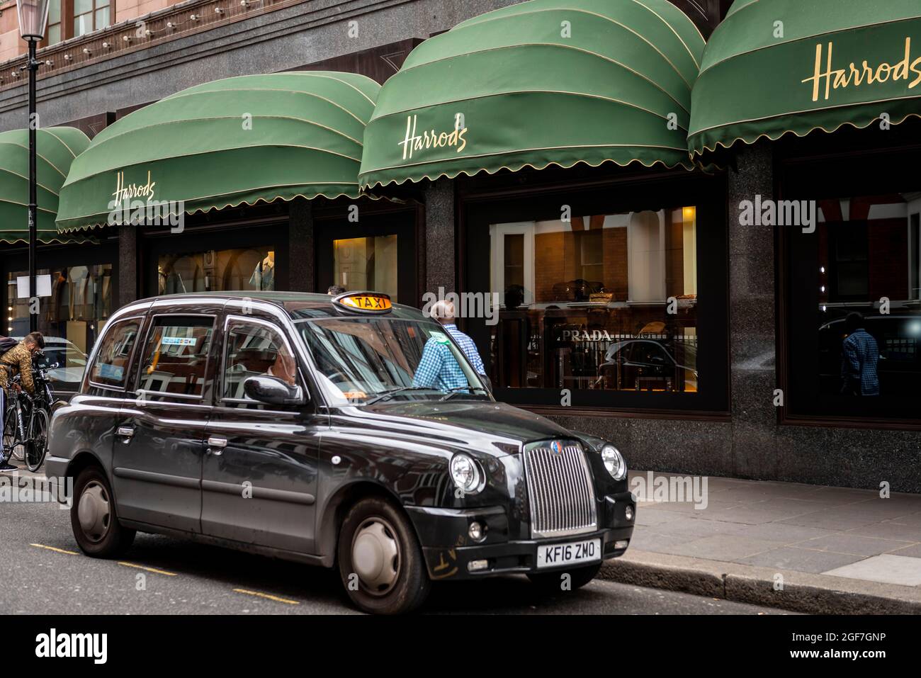 Black London Taxi fuori dai grandi magazzini di lusso, Harrods, Londra, Inghilterra, Regno Unito Foto Stock