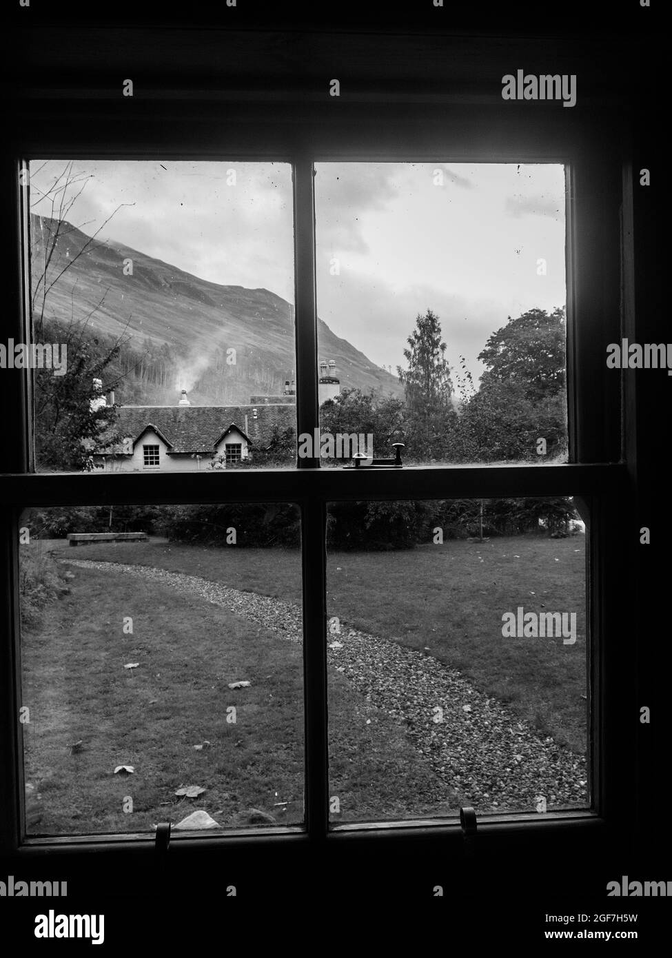 Vista dalla finestra di una casa di campagna in legno in bianco e nero Foto Stock