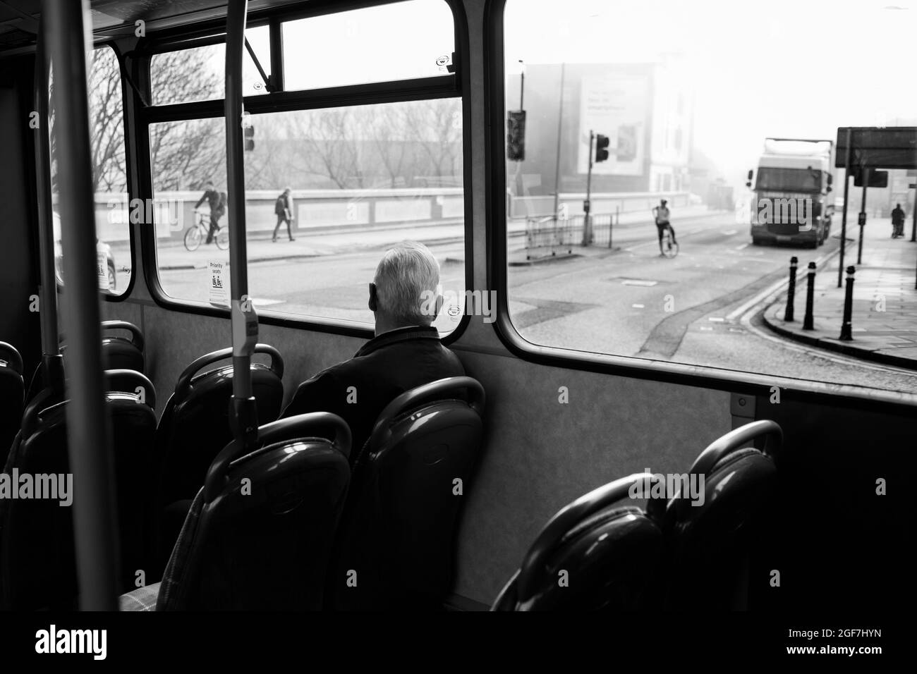 Abitacolo dell'autobus con un passeggero che guarda fuori dal finestrino. Foto Stock