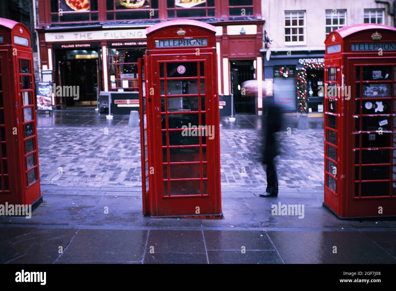 Tre tradizionali vecchie scatole telefoniche rosse sul lato del Royal Mile a Edimburgo, Lothian, Scozia Foto Stock