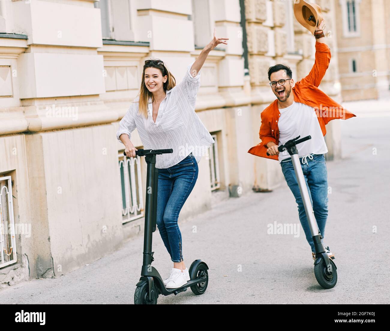 coppia giovane scooter elettrico città trasporto equitazione tecnologia lifestylestreet amico guida moderno Foto Stock
