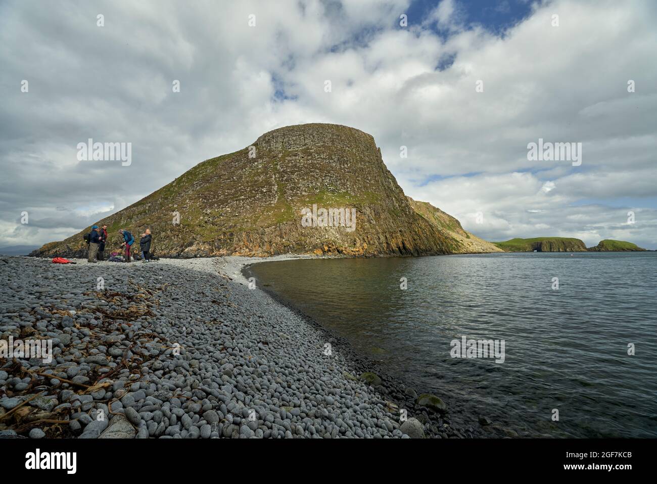 I visitatori in una gita di un giorno alle isole scianti che arrivano sull'istmo roccioso che unisce Garbh Eilean ed Eileen an Taighe. Foto Stock