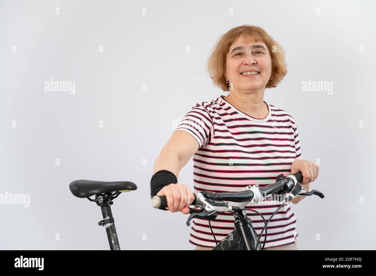 Donna anziana su una bicicletta su uno sfondo bianco Foto stock - Alamy