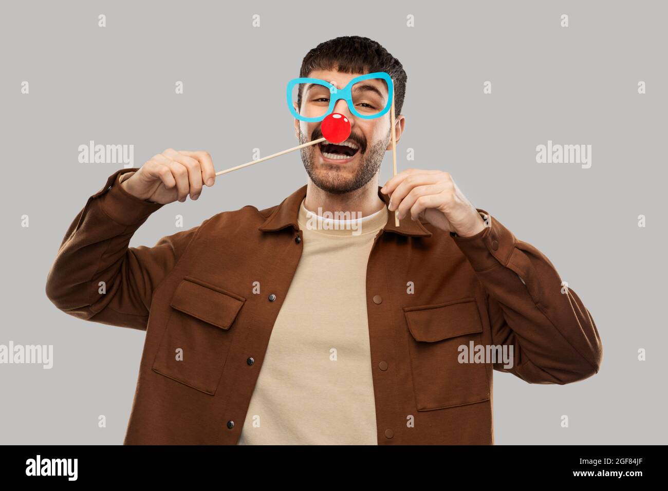 uomo felice sorridente con occhiali e naso rosso clown Foto Stock