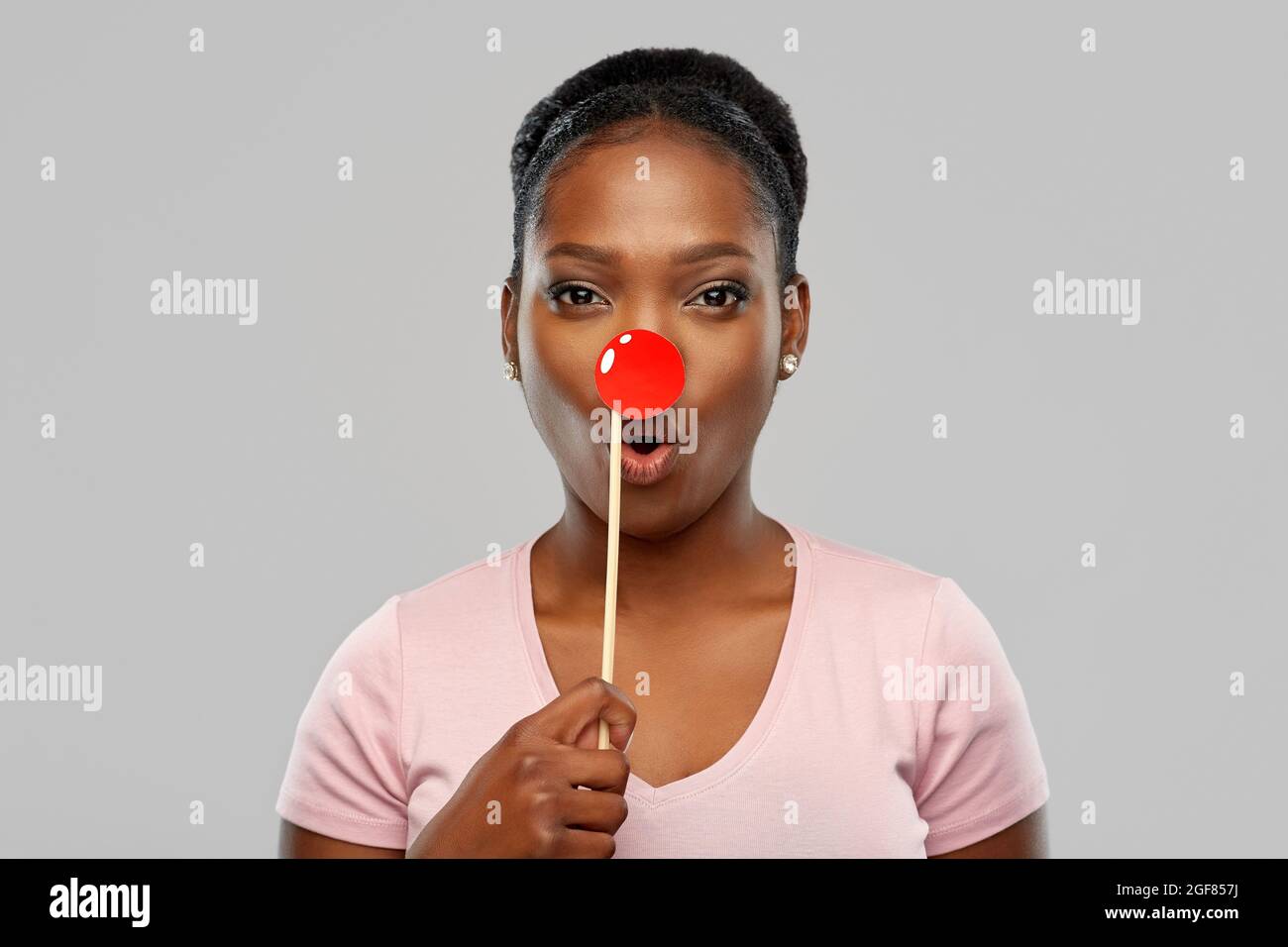 sorprende la donna africana con il naso rosso del clown Foto Stock