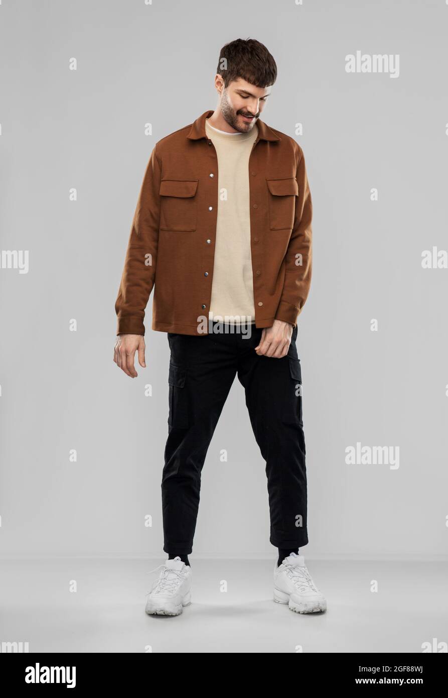 giovane uomo in giacca marrone e pantaloni neri Foto stock - Alamy