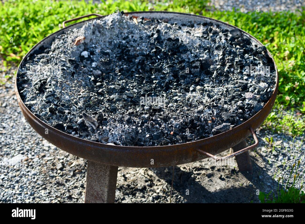 Feuerschale auff Füßen mit Kohle gefüllt Foto Stock