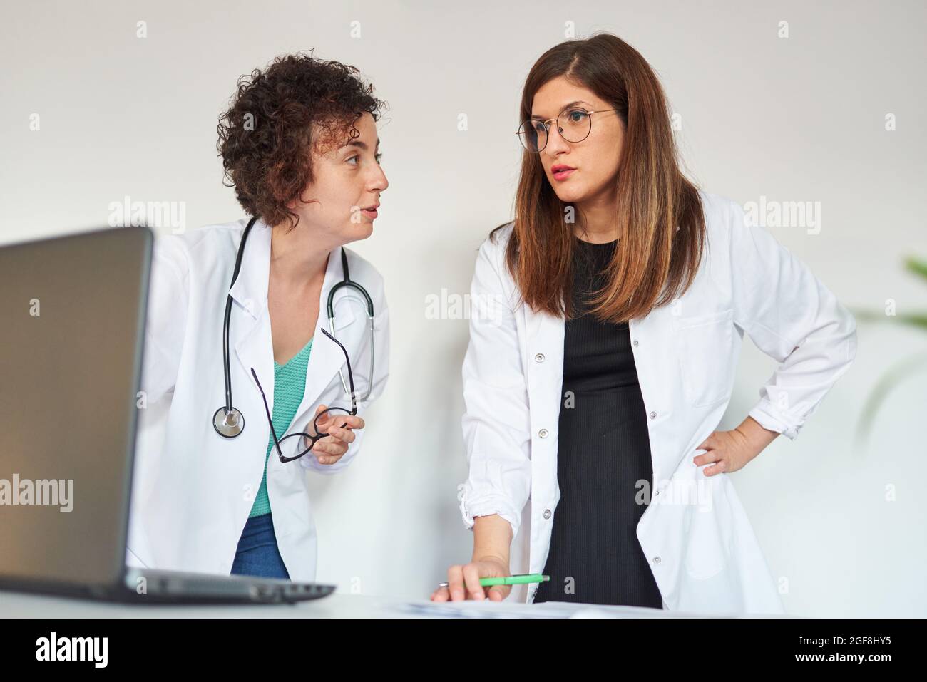 Due medici di sesso femminile che lavorano davanti a un computer portatile Foto Stock