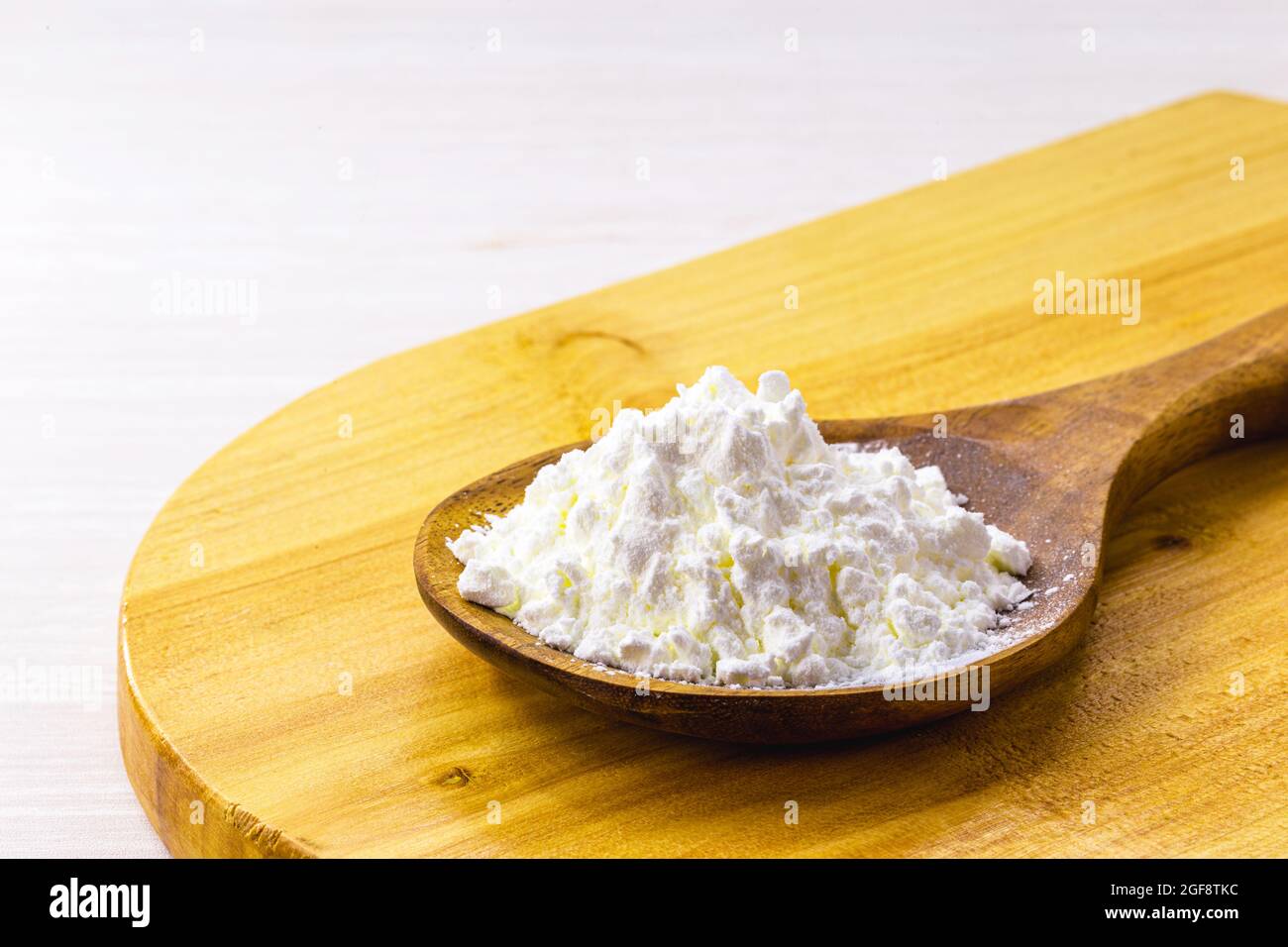 cucchiaio di amido di mais, farina di mais usata per fare creme o come addensante. Sfondo bianco, spazio di copia Foto Stock