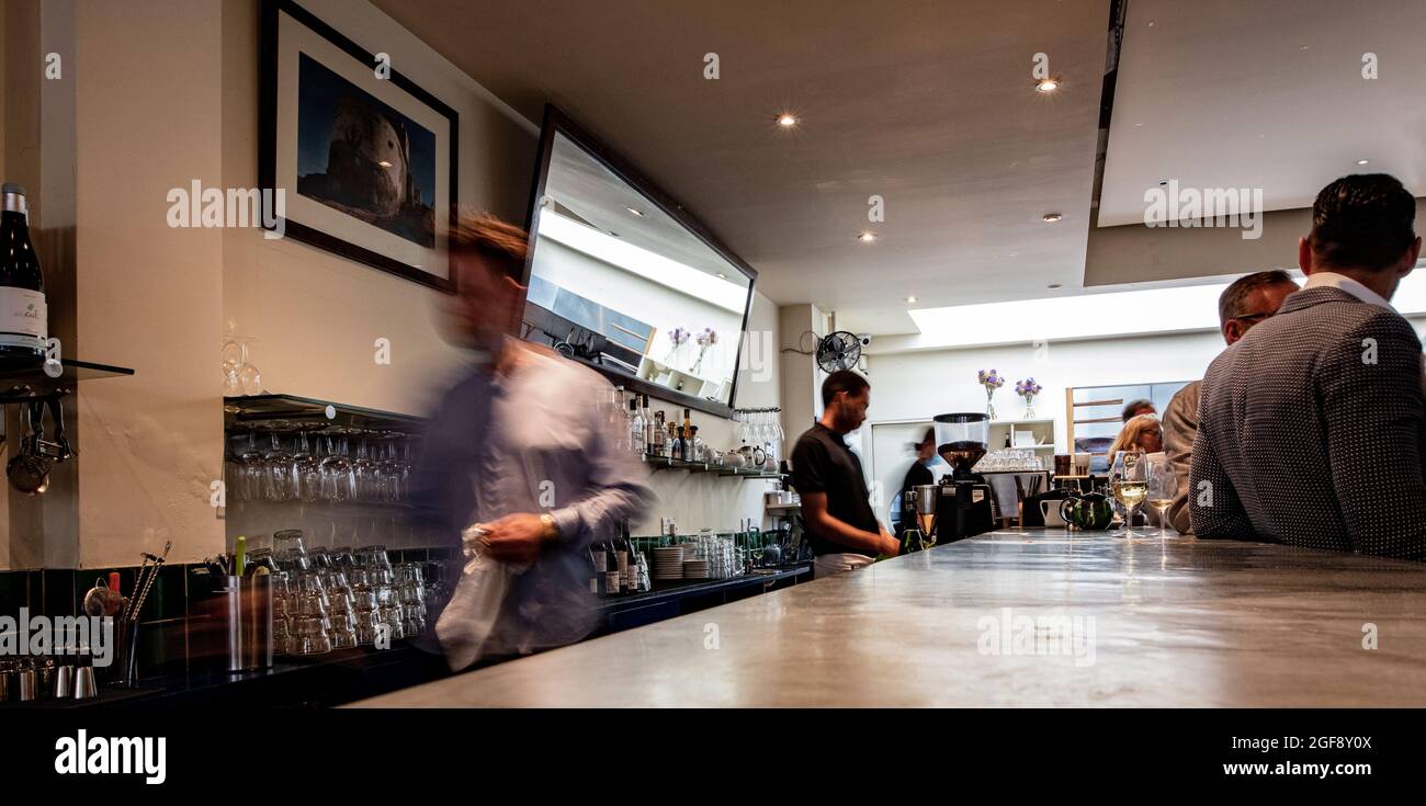 Vista dietro il bar a Moro, Exmouth Market, Clerkenwell, Londra; un ristorante di alto livello specializzato in cucina marocchina; blurred shot di personale Foto Stock