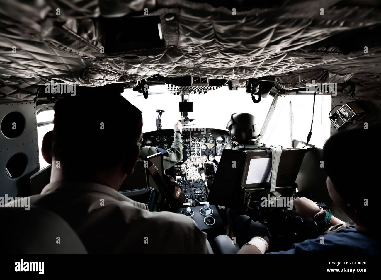 Elicottero militare cockpit con due piloti e due passeggeri in volo durante la pattuglia di confine. Messa a fuoco selettiva. Foto Stock