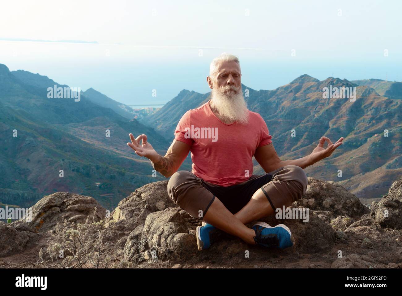 Uomo anziano saluto tramonto Foto Stock