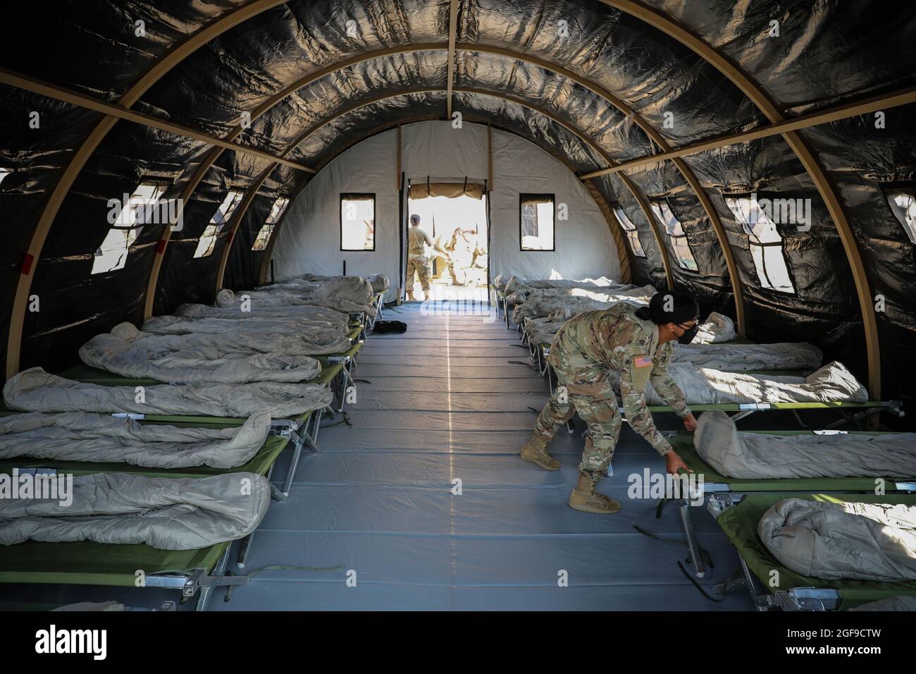 US Army Soldier PFC. Dayshia Wiggins con il 21° comando di sostegno al teatro, assembla le culle all'interno di alloggi temporanei per i rifugiati afghani alla base aerea di Ramstein il 21 agosto 2021 a Ramstein-Miesenbach, Germania. La base aerea di Ramstein fornisce alloggio temporaneo per gli sfollati dall'Afghanistan come parte del Refuge Operation Allees. Foto Stock