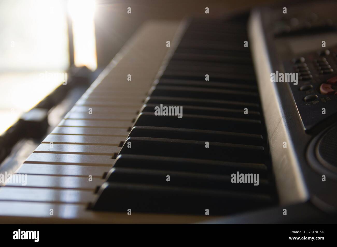 Primo piano sui tasti della tastiera in bianco e nero con la luce del sole che entra attraverso la finestra. Compositore domestico, creazione d'arte, concetti di ispirazione Foto Stock