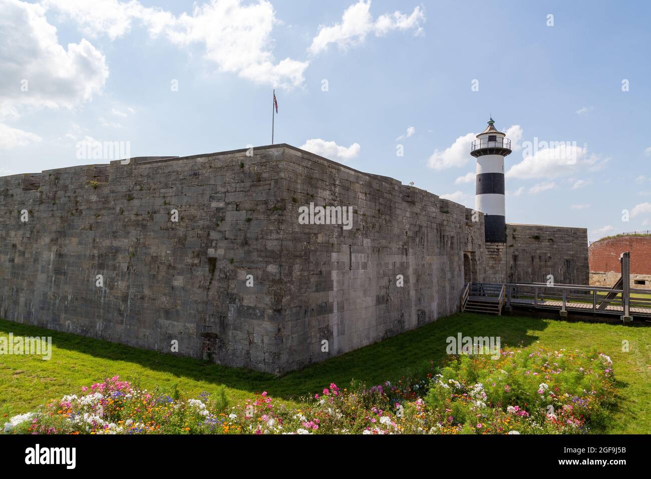 08-24-2021 Portsmouth, Hampshire, UK, The Exterior of Southsea Castle and Lighthouse in a Summer day with flowers in the foreground Foto Stock