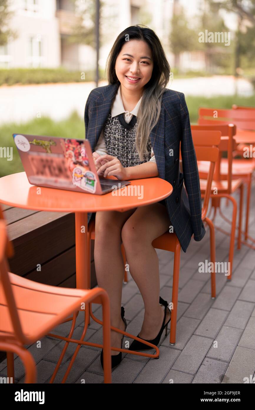Giovane Asian Female Data Scientist che si diverse a lavorare all'esterno Foto Stock