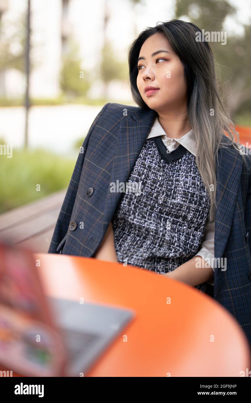 Giovane Asian Female Data Scientist che si diverse a lavorare all'esterno Foto Stock