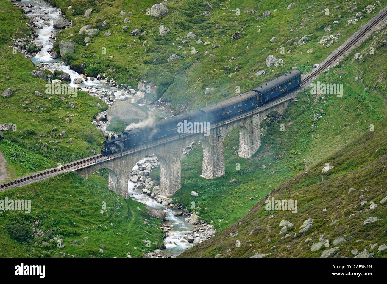 Treno a vapore Furka attraverso i paesaggi montani delle Alpi centrali sulla storica Glacier Express. Furkapass, Svizzera - Agosto 2021 Foto Stock