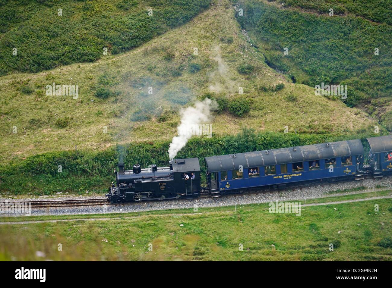 Treno a vapore Furka attraverso i paesaggi montani delle Alpi centrali sulla storica Glacier Express. Furkapass, Svizzera - Agosto 2021 Foto Stock