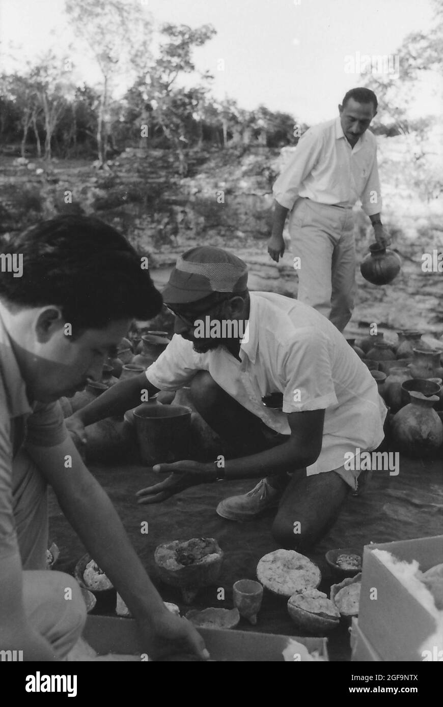 Román Piña Chán (in posizione arretrata) e Victor Segovia Pinto (cappello) che smistano manufatti maya recuperati dal cenote sacro xtoloc a Chichen Itza, 1967 Foto Stock