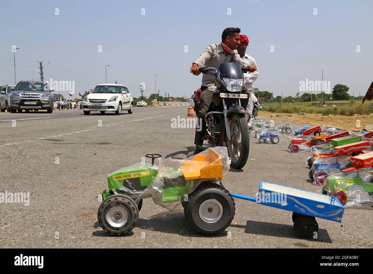 Beawar, India. 24 agosto 2021. Venditore di strada che vende giocattoli per veicoli, mentre molti veicoli passano sulla Ahmedabad-Delhi National Highway a Beawar. (Foto di Eric Dubost/Pacific Press) Credit: Pacific Press Media Production Corp./Alamy Live News Foto Stock